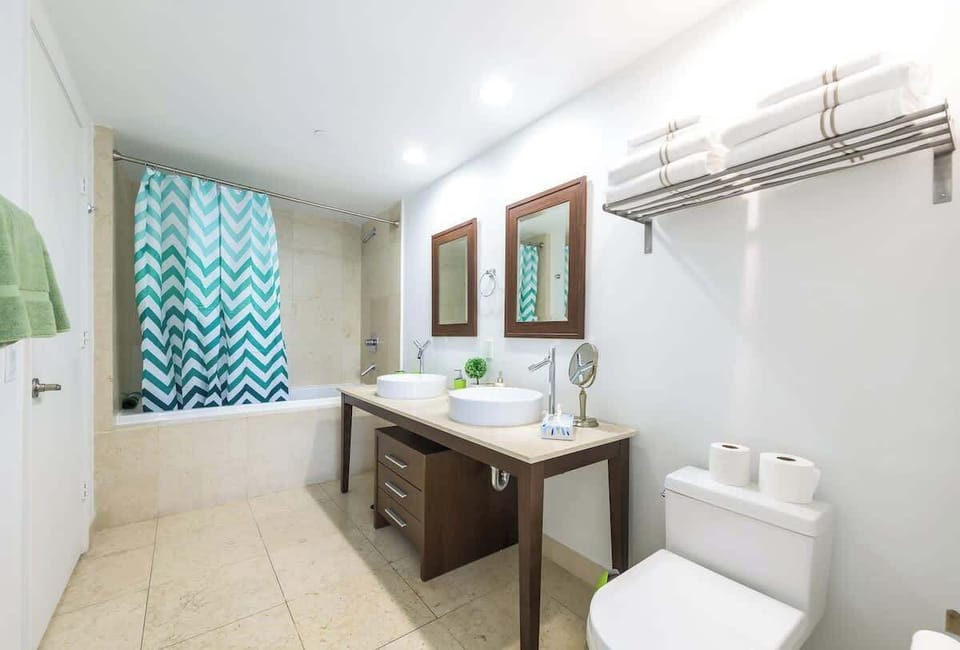 "Freshen up in this bright Airbnb bathroom with double sinks, modern design, and cozy vacation rental comfort."

