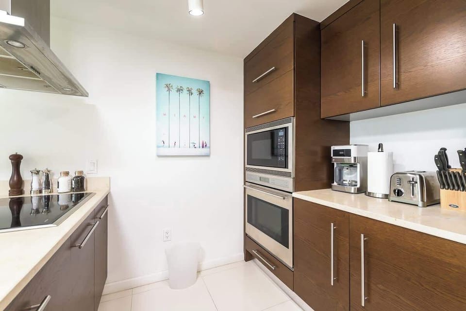 "Cook with ease in this modern Airbnb kitchen featuring sleek cabinetry, stainless steel appliances, and a cozy vacation rental vibe."