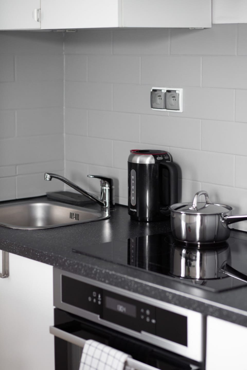 The white cabinets blend in perfectly with the black worktop, which houses the hob and kettle.