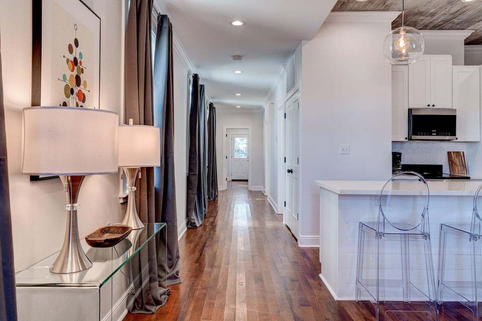 Sun-lit hallway leading to the bedrooms — clean lines & warm wood floors.
