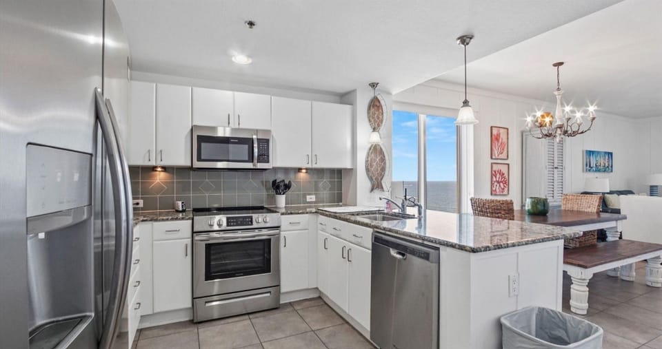 Your modern kitchen features sleek white cabinets, granite countertops, and stainless steel appliances ready for your culinary adventures.