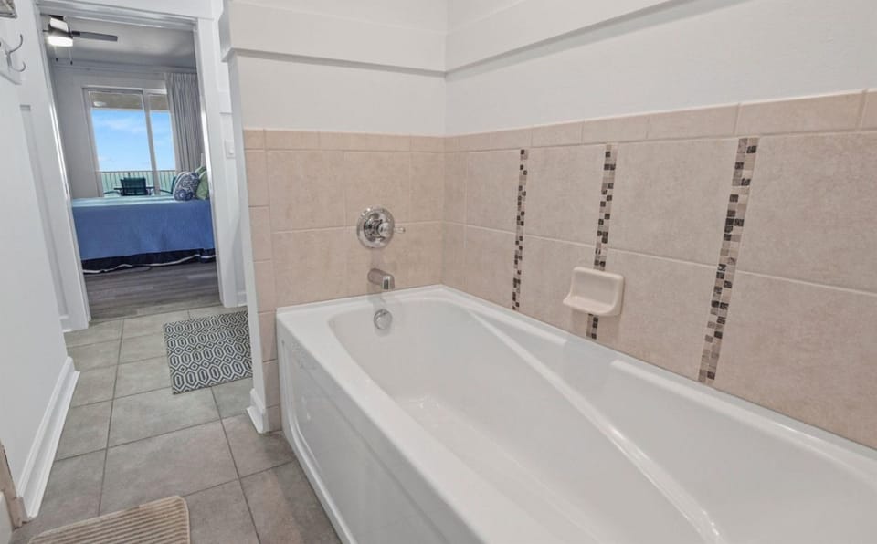 Sink into your private soaking tub surrounded by elegant tile work, with glimpses of the ocean beyond.