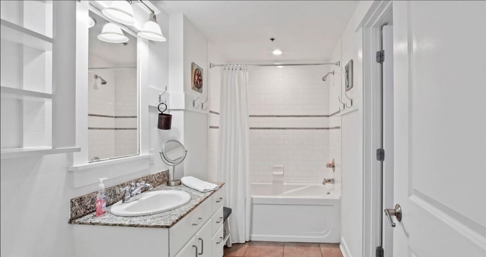 Refresh in your pristine bathroom featuring granite countertops, a soaking tub, and crisp white finishes that create a spa-like retreat.