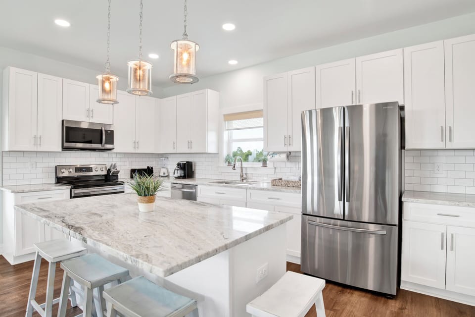 Open kitchen with 5 bar stools and a large Island for everyone to gather around. Stainless steel appliances