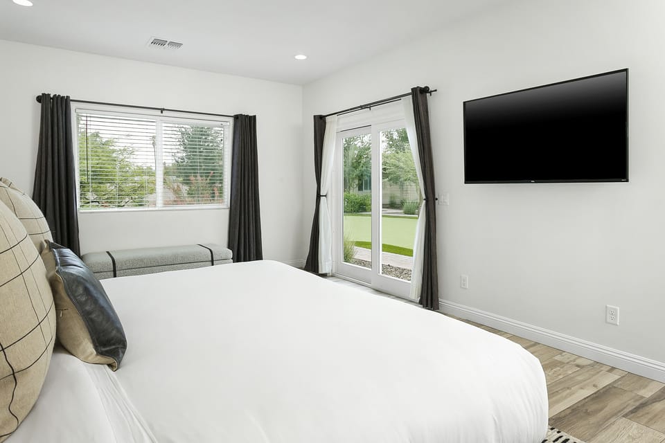 Primary Bedroom: king bed with en-suite bathroom and backyard access