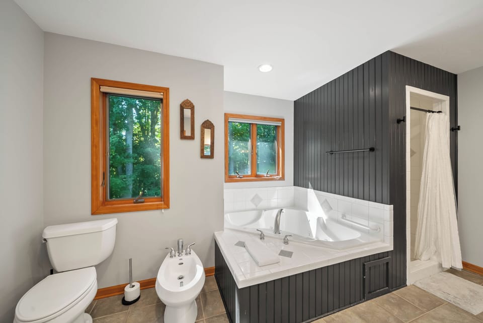 Soak away the day in this spacious bathroom with a jetted tub, wooded views, and a separate shower just steps away.