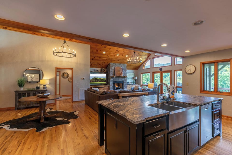 Cook, gather, and relax all in one sweeping space. The stone fireplace and vaulted wood ceiling set the perfect mountain mood.