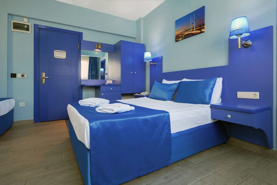 Deluxe Quadruple Room | In-room safe, desk, blackout drapes, bed sheets