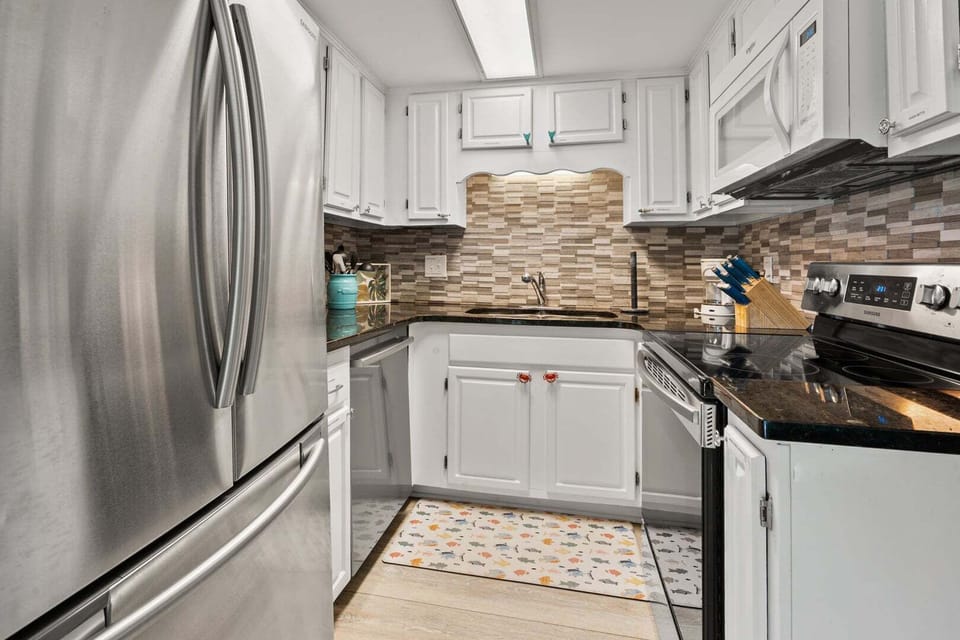 Kitchen with white cabinetry, dark counters and a full-size oven at Sea Lakes 103C, Cherry Grove