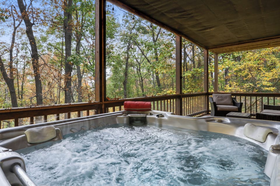 Soak in the bubbling hot tub with serene forest views all around.