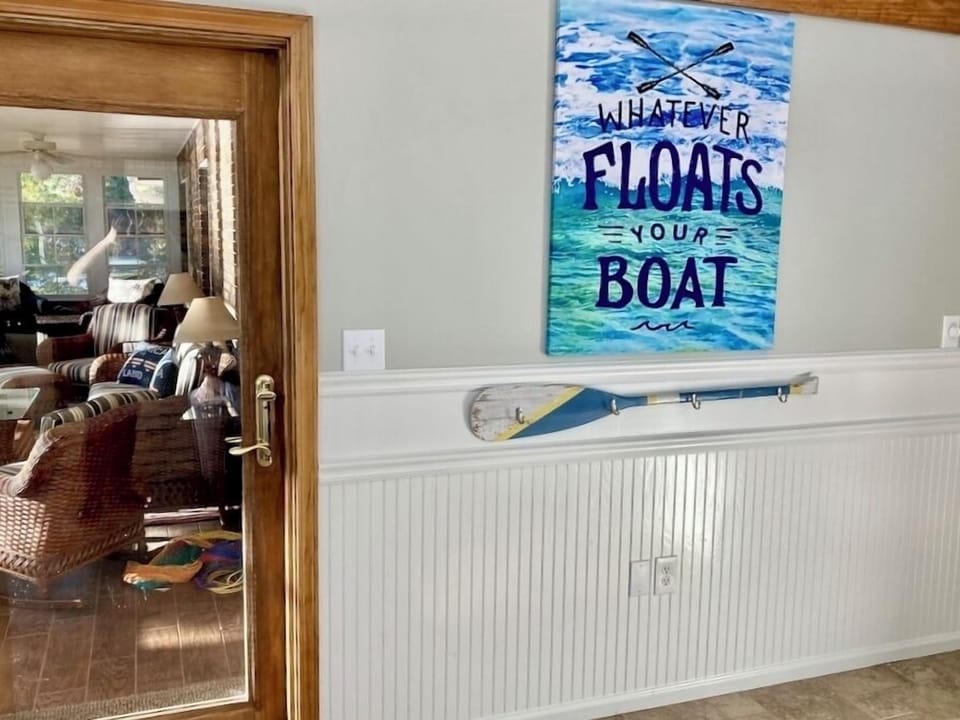 Door to 3 season porch has paddle with hooks to the right for hanging lake towel