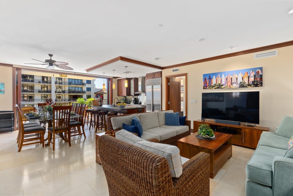 Living room with two couches and a chair around a 65” HD Smart TV, upgraded cable and high-speed internet.