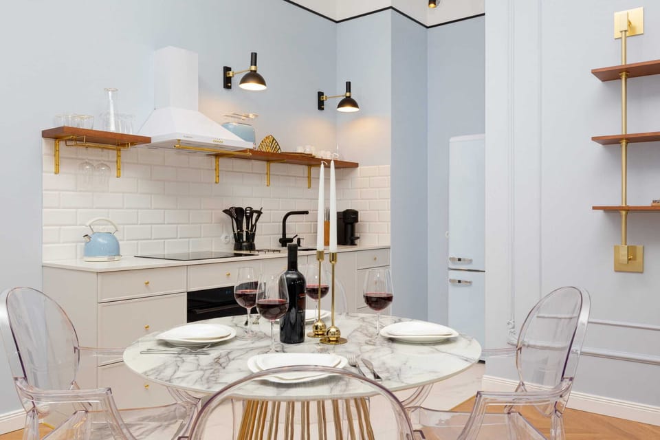 Dining table with tableware and kitchenette.