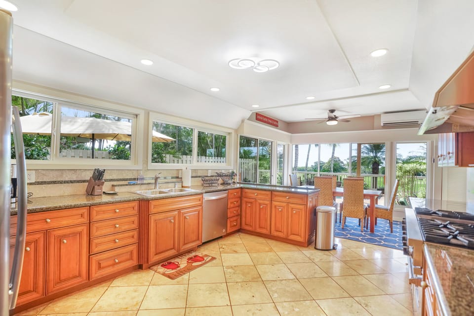 Spacious gourmet kitchen and dining areas open up to the pool de