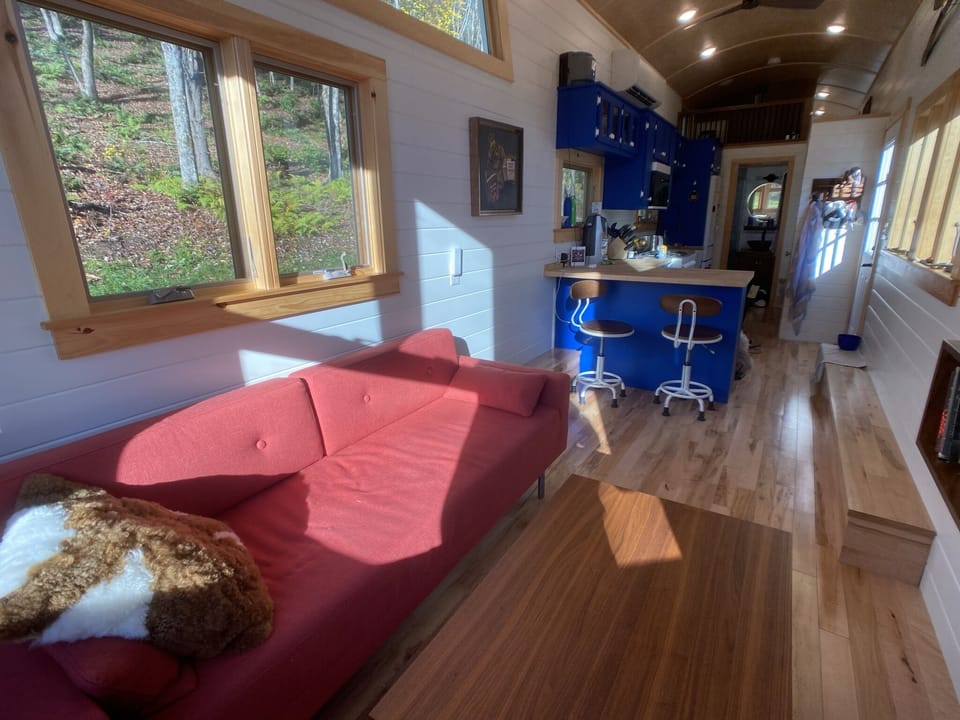 Living area with sofa bed and coffee table that converts to desk or dining table
