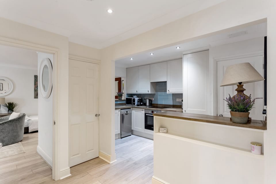 Open plan hallway with Washer/Dryer laundry machine in cupboard.