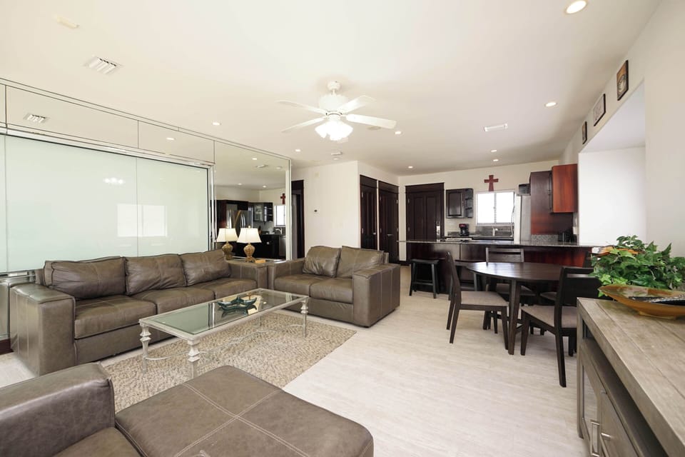 Relax in your spacious open-plan living area with plush leather seating and modern kitchen—perfect for unwinding after exploring.