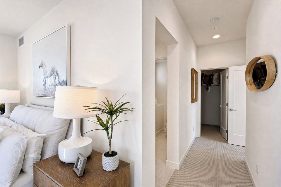 Relax in your serene bedroom retreat with plush bedding and thoughtful touches, then step into the bright hallway leading to your private closet and bathroom.