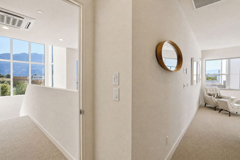 Bright hallway connects you to serene spaces with stunning mountain views. Soft carpet underfoot and natural light create a welcoming path to your next favorite spot.