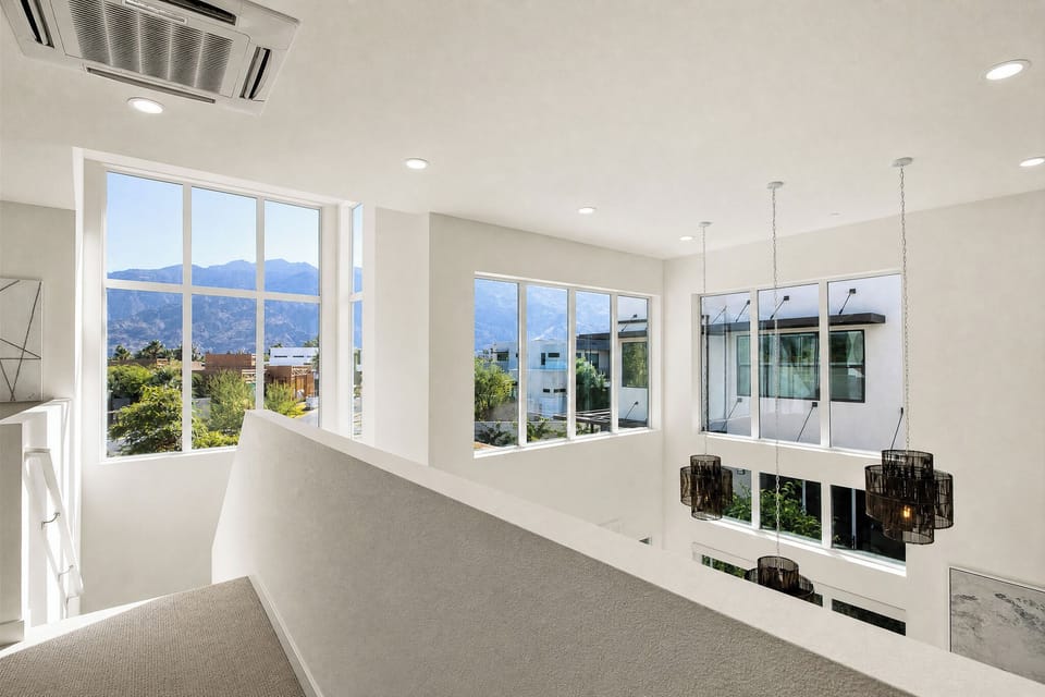 Bright, airy loft space with stunning mountain views through oversized windows. Picture yourself enjoying the scenic beauty from this elevated vantage point with modern climate control overhead.