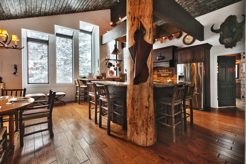Hardwood floors throughout the dining and kitchen area, wooden log support beam
