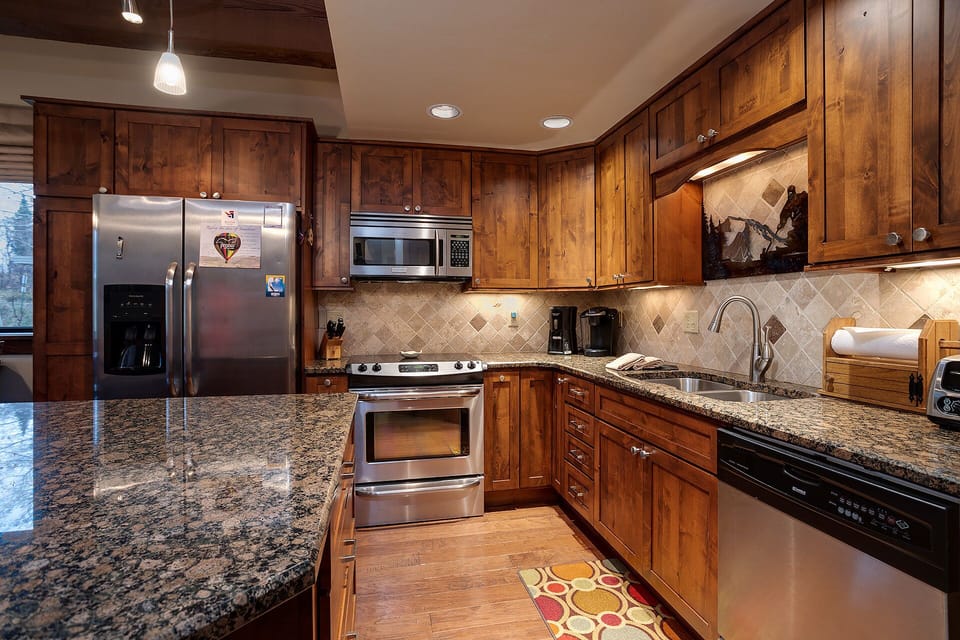 Your gourmet kitchen awaits with rich knotty alder cabinetry, granite counters, and premium appliances for memorable meals together.