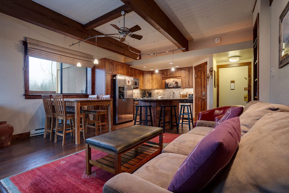 Your mountain retreat blends rustic charm with modern comfort—exposed beams, cozy seating, and a gourmet kitchen await your memorable stay.