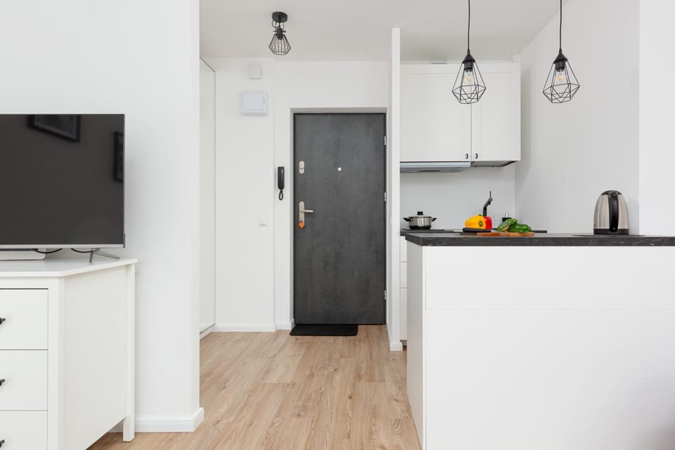 TV and fully equipped kitchenette with kitchen island, electric kettle, fridge freezer, induction hob and coffee maker.