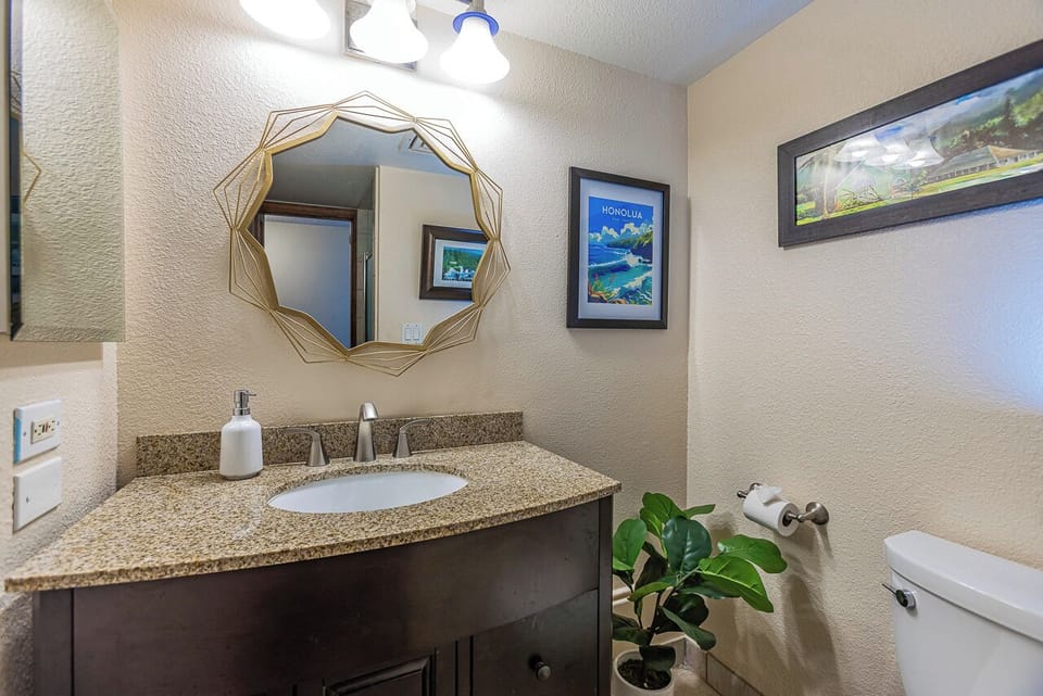 Freshen up in your stylish bathroom with its modern granite vanity, geometric mirror, and tropical touches. Everything you need is right here for a comfortable stay.