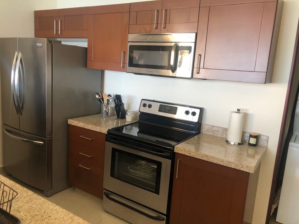 Fully equipped kitchen with pots, pans, utensils, glass, dining, and silverware.