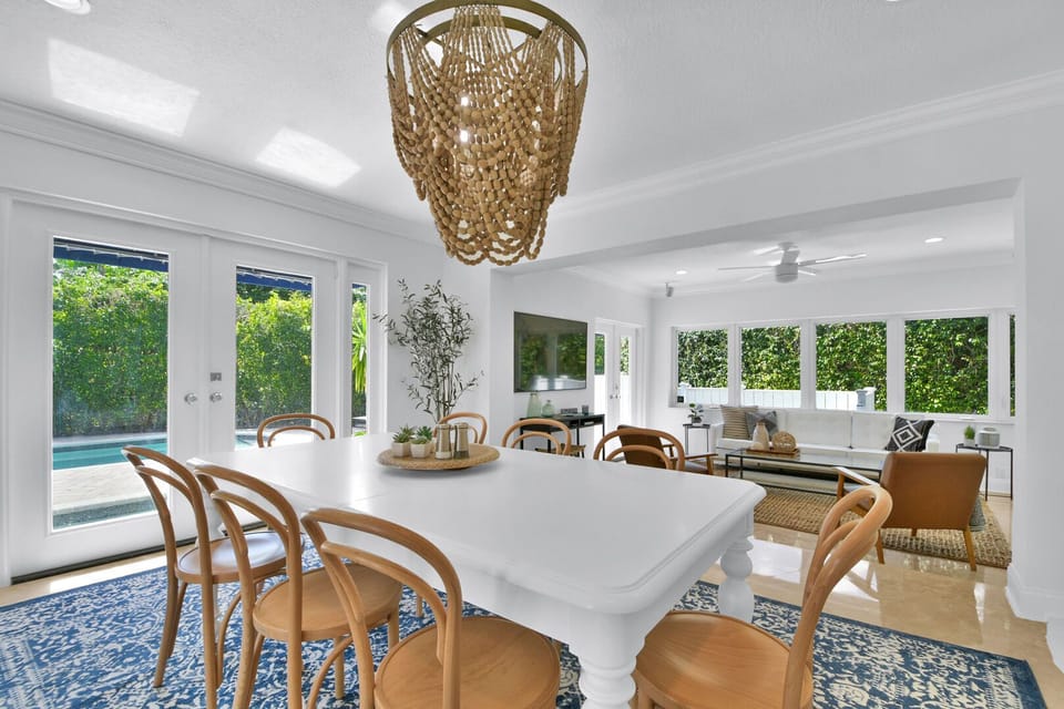 Dining Room surrounded by glass is bright, airy and spacious enough to seat 8 comfortably