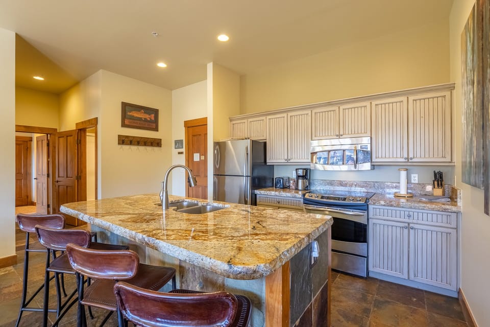 Kitchen, hallway to queen suite, hall bath, and queen bedroom in left of photo