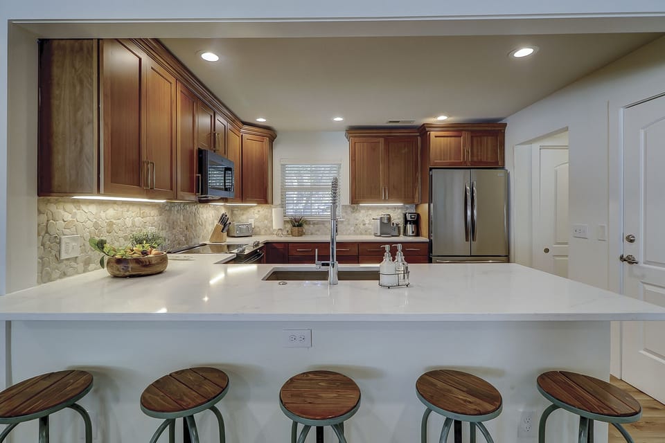 Newly remodeled main kitchen with new appliances and bar seating.