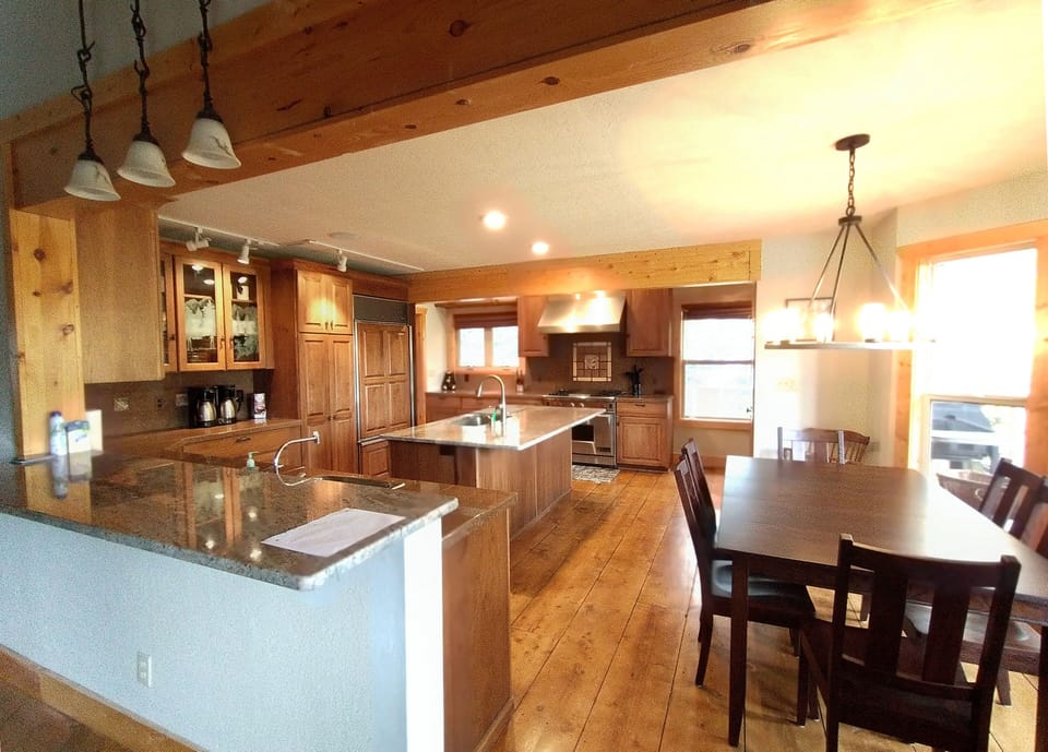 Custom kitchen features high end appliances, an island and a breakfast table