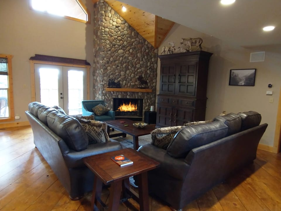 The Great Room has beautiful views, a wood burning stone fireplace and TV