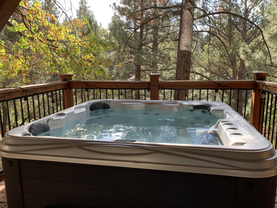 Spa on downstairs deck overlooking forest and Sisters Cove
