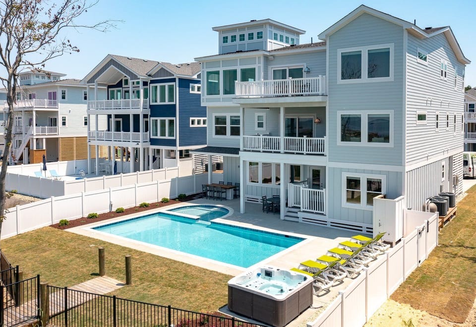 Aerial view of Sunset Serenade, highlighting the private pool, kiddie pool, hot tub, and soundfront pier.