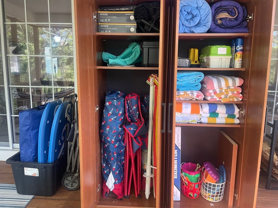 Cabinet in screened porch with beach and fishing supplies, inc. 2 coolers