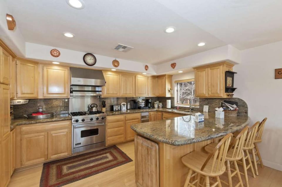 Kitchen features modern appliances and barstool seats.