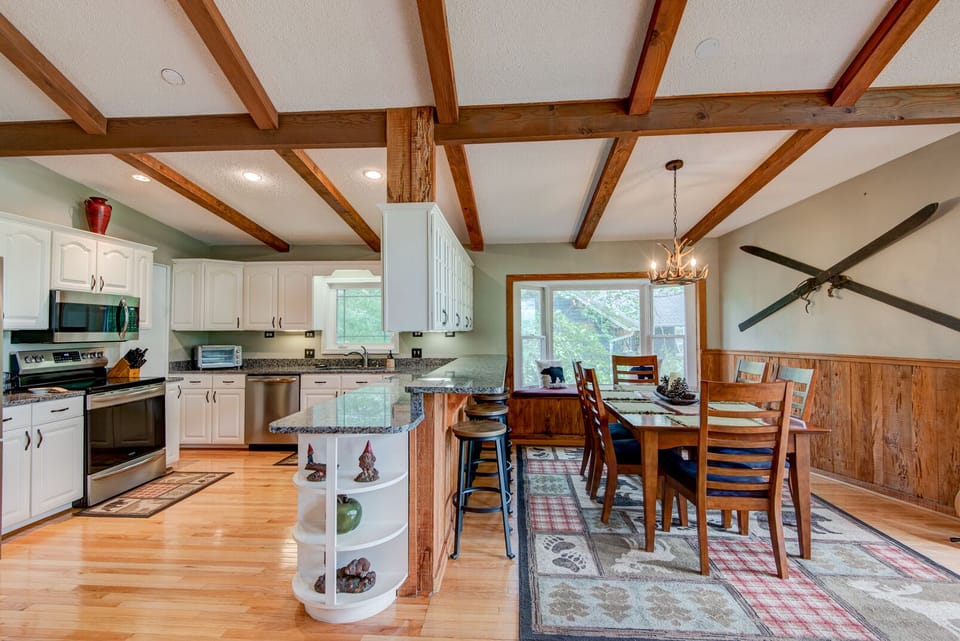 Gather around the dining table after a day on the mountain, with the open kitchen just steps away under warm wood beams.