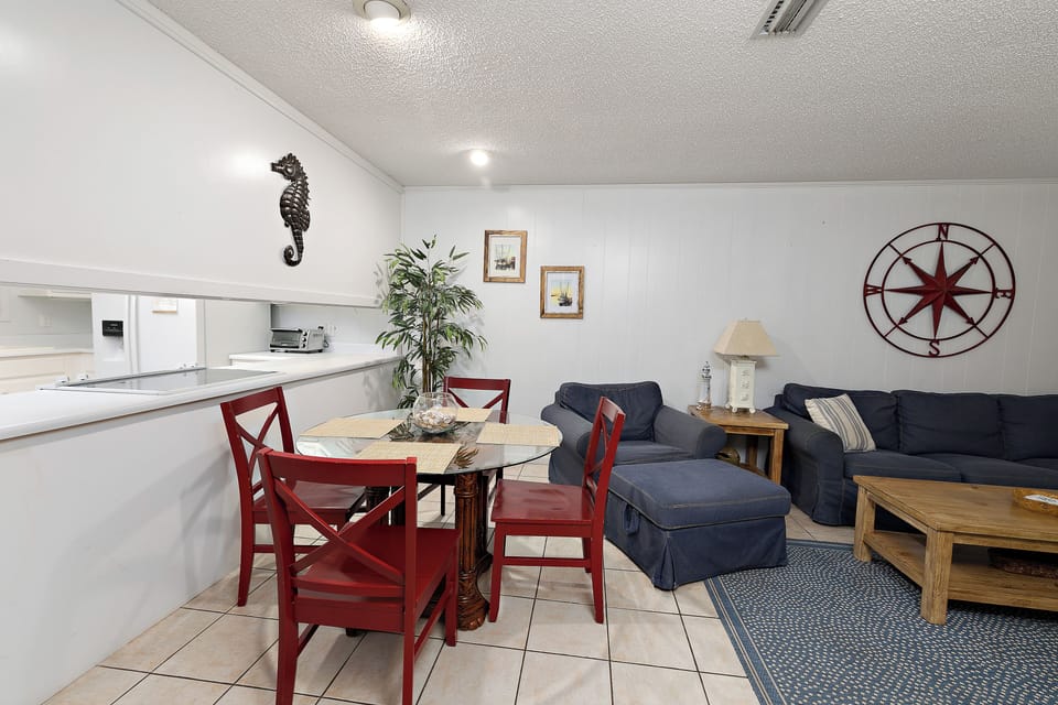 Dining nook with red chairs beside navy living room