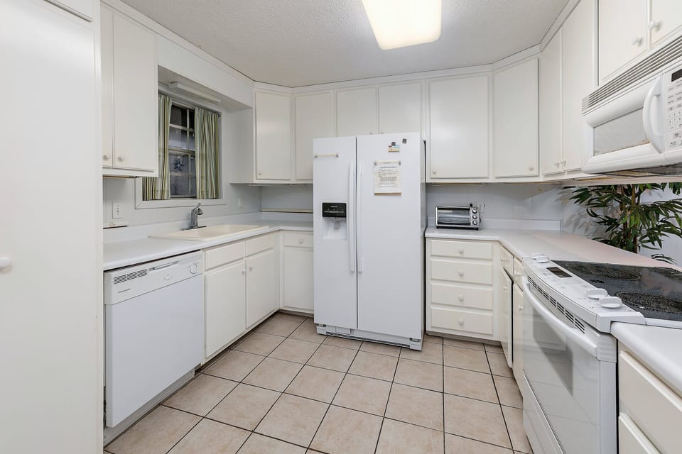 White kitchen with white appliances and tile counters