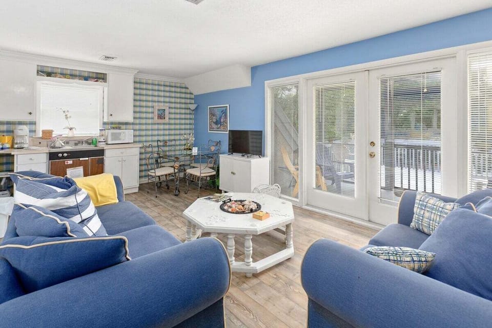 Living room with blue sofas, sliding doors, and blue accent wall