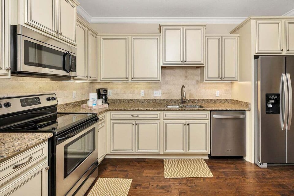 Kitchen with cream cabinets, granite counters, and stainless appliances