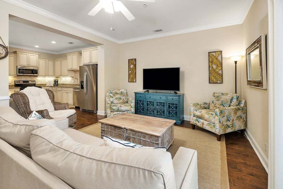 Living room with sofa, floral chairs, TV, and blue cabinet