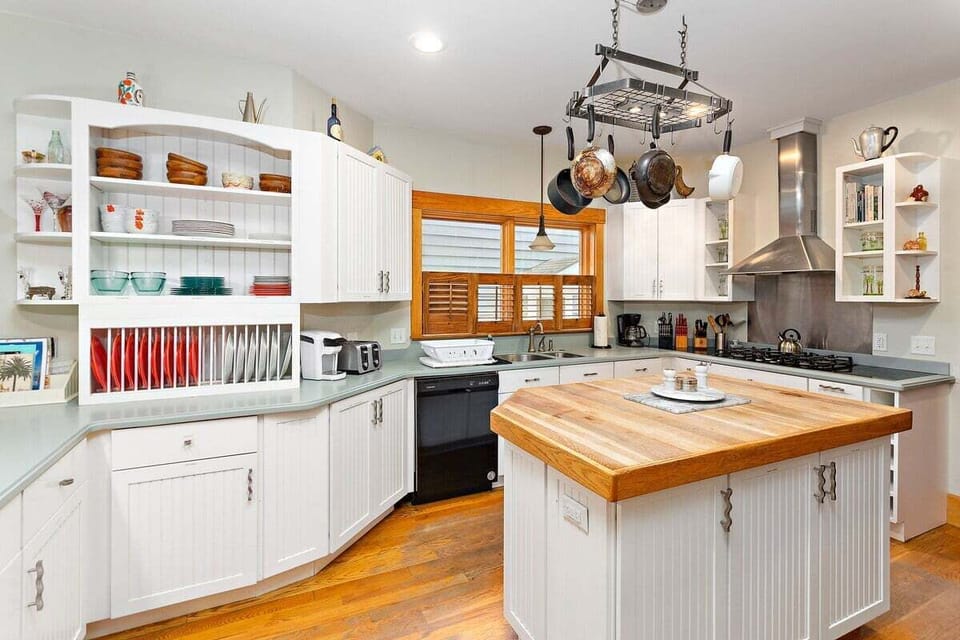 White kitchen with butcher block island and open shelving
