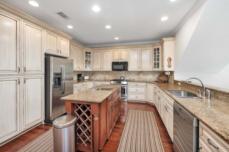 Kitchen with island wine rack and stainless appliances