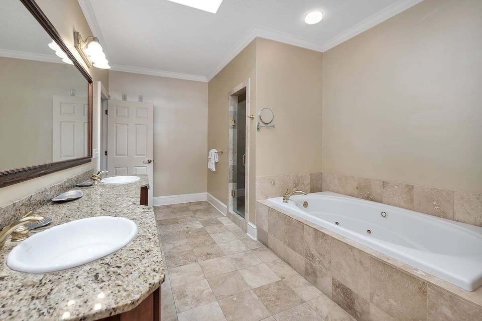 Spa bathroom with soaking tub and granite double vanity