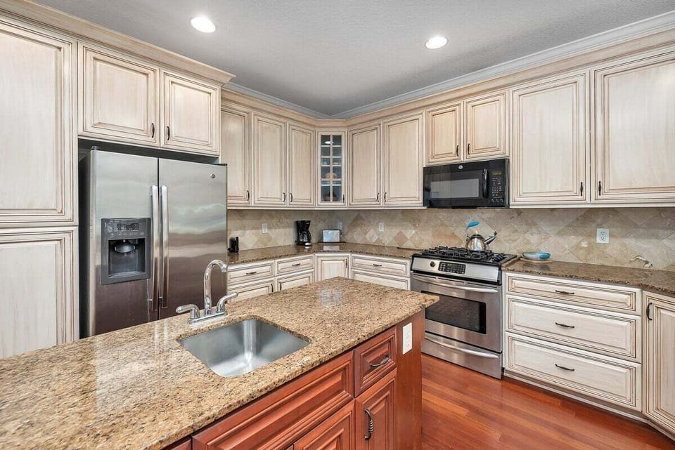 Kitchen with granite island sink and stainless appliances