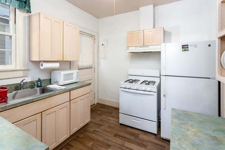 Light wood kitchen with white appliances and dark countertops